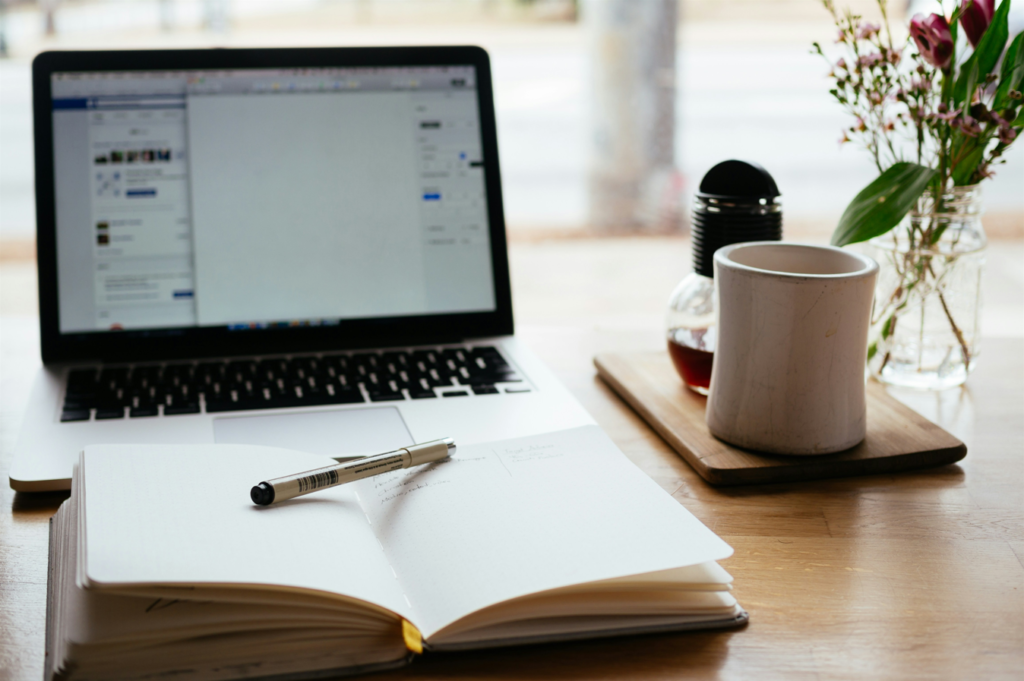 notebook, laptop and coffee representing repurposing content