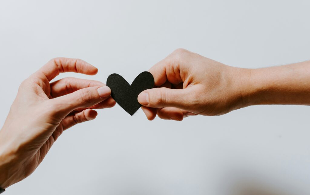 two hands are holding a paper heart representing giving likes to UGC